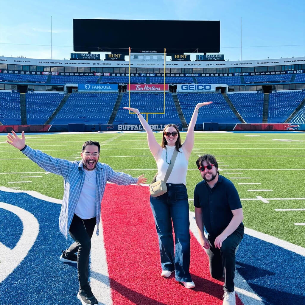 Buffalo Bills Twipes Instagram post Social media post of two men and a woman stand proudly on the Buffalo Bills football field, smiling with their arms up in celebration